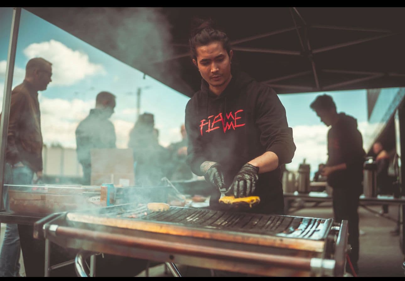 Mann lager burger på grill